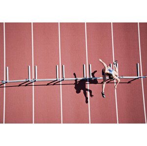 Umělecká fotografie Runner jumping hurdles on track, Paul Bradbury, (40 x 26.7 cm)